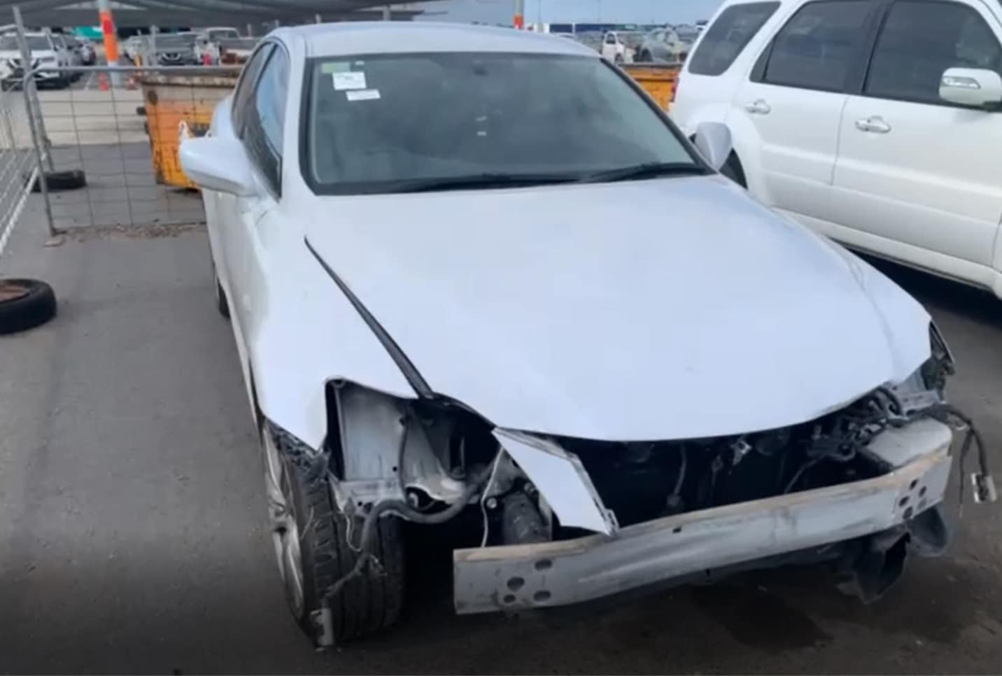 White car with front-end damage in a vehicle yard