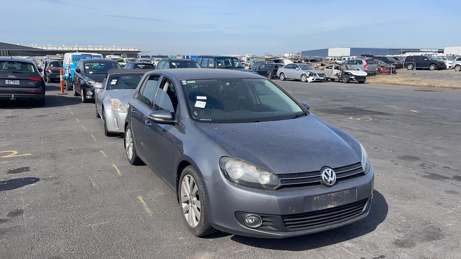 Grey hatchback in a vehicle yard