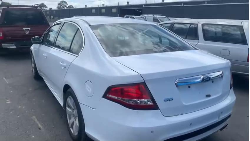 Cash for Cars Warrandyte 1 White sedan photographed from the rear in a vehicle yard